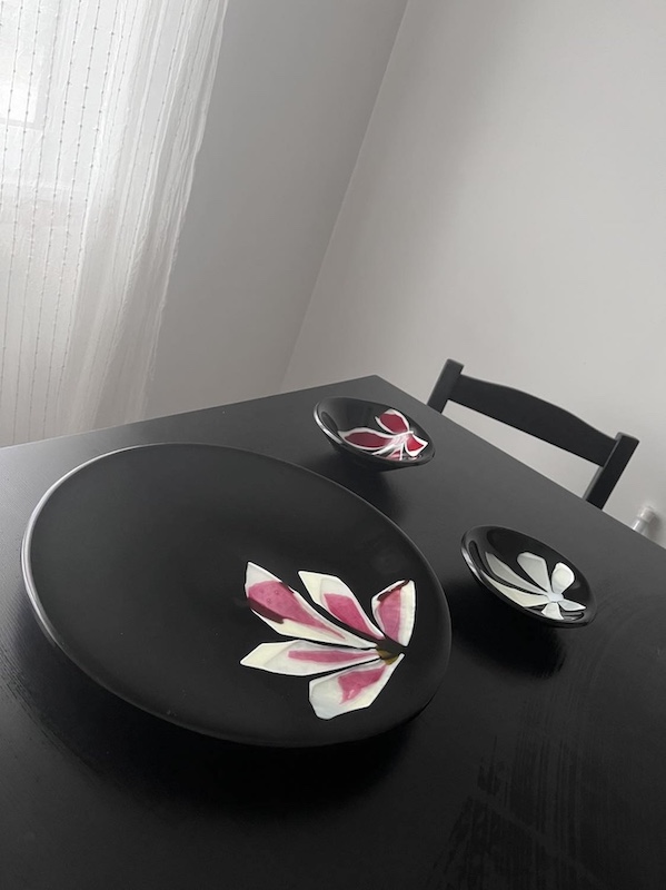 table noire avec assiettes de verre noir et fleur roses