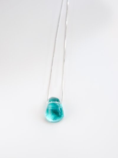 Pendentif en verre fusionné bleu aqua, translucide et brillant, suspendu à une fine chaîne en argent sterling.